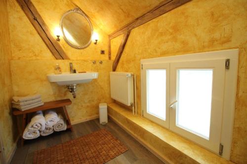 ein Bad mit einem Waschbecken und einem Fenster in der Unterkunft Kiek mol in in Grömitz