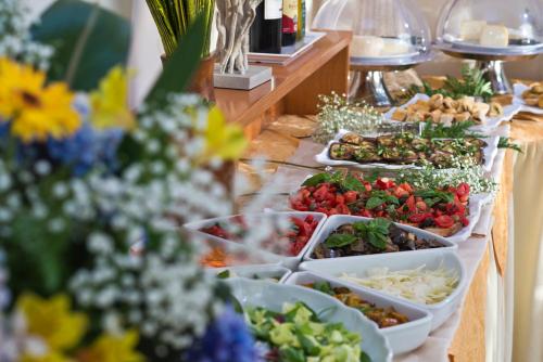 a buffet of food on a table with flowers at Hotel Casa Di Meglio in Ischia