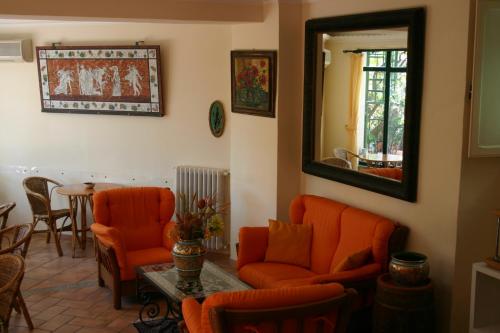 a living room with orange chairs and a mirror at Villa Gaia in Taormina