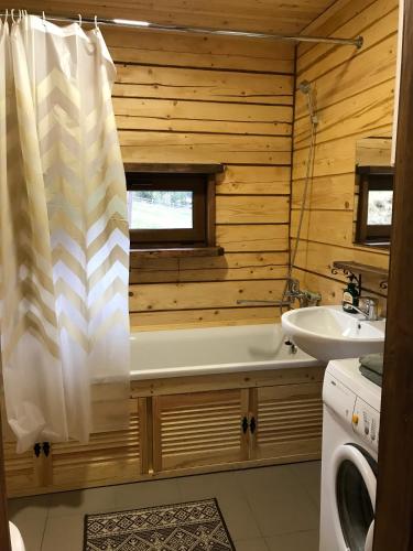 a bathroom with a bath tub and a sink at Kozichky Guest House in Tatariv