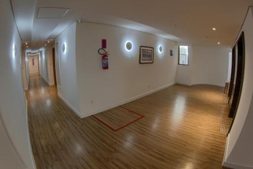 an empty room with white walls and a wooden floor at Marante Executive Hotel in Recife