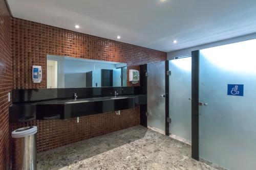 a bathroom with two sinks and a mirror at Marante Executive Hotel in Recife