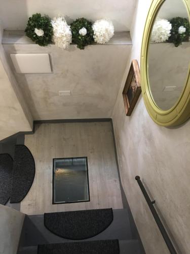 a staircase with a mirror and flowers on the wall at Il Pozzo di Santa Zita in Lucca