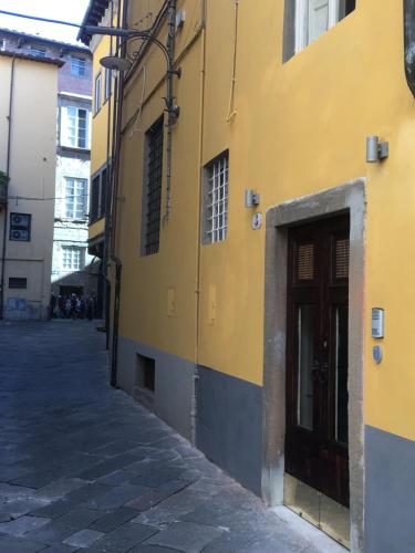 a yellow building with a door on a street at Il Pozzo di Santa Zita in Lucca