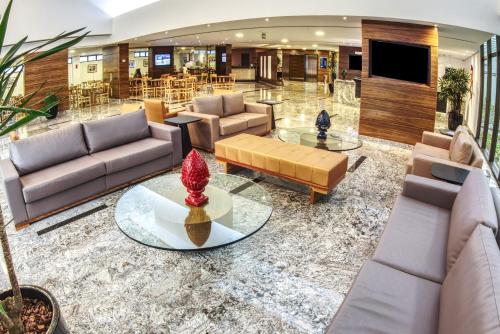 a lobby with couches and a table in a building at Marante Executive Hotel in Recife
