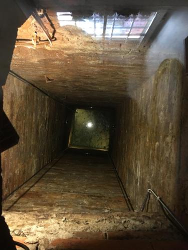 a dark tunnel with a light at the end of it at Il Pozzo di Santa Zita in Lucca
