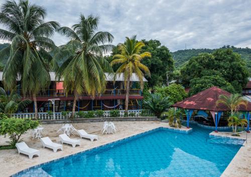 a resort with a swimming pool and palm trees at Tacarcuna Lodge in Capurganá
