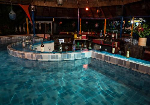 a swimming pool with a bar in the middle at Tacarcuna Lodge in Capurganá
