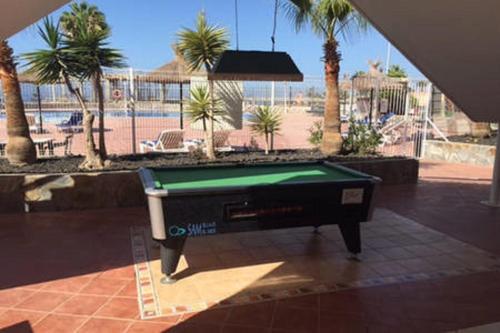 a pool table in a courtyard with palm trees at C108 Bright accommodations in Adeje