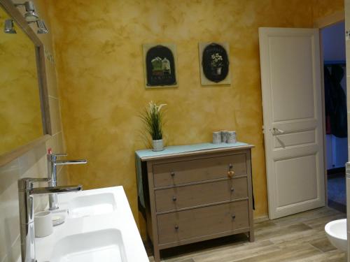 La salle de bains est pourvue d'un lavabo et d'une armoire avec une plante. dans l'établissement 13 Rue du Tour d'Enceinte, à Pomérols