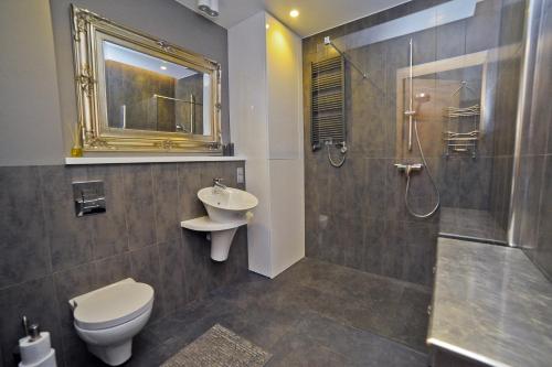 La salle de bains est pourvue de toilettes, d'un lavabo et d'une douche. dans l'établissement Africana Apartment by Grand Apartments, à Sopot