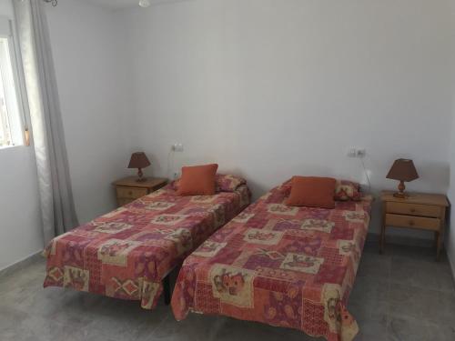 ラ・マリーナにあるDetached Extended Lola Villaのベッドルーム1室(ベッド2台、ランプ付きのナイトスタンド付)