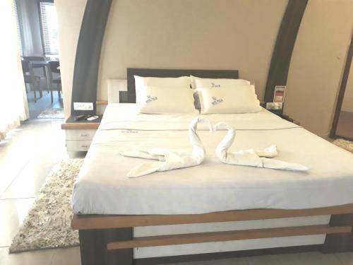 a bed with two white towels on top of it at Hotel Pooja International in Dāvangere