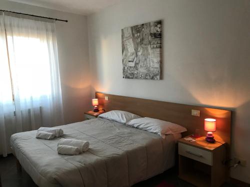 Affittacamere Fiumicello في Papariano: غرفة نوم عليها سرير وفوط