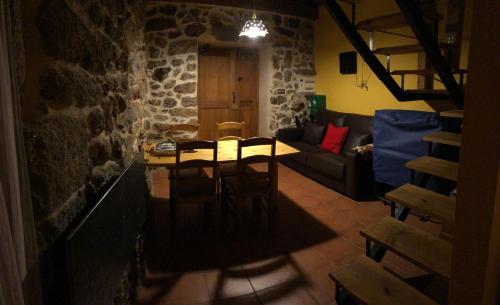 salon ze stołem i kanapą w obiekcie Apartamentos Rurales A Torre w mieście Porquera