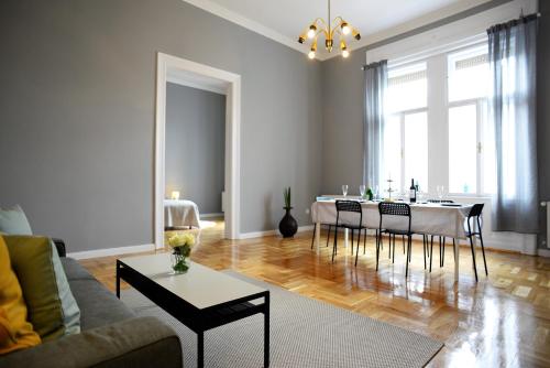 ブダペストにあるBudapest Danube Panorama Apartmentのリビングルーム(ソファ、テーブル、椅子付)