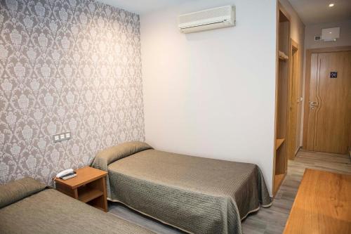 Habitación pequeña con cama y sofá en Hotel Simancas, en Simancas