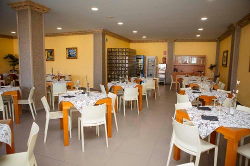 une salle à manger avec des tables et des chaises blanches dans l'établissement Hotel Simancas, à Simancas