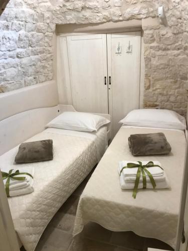 2 Betten in einem Zimmer mit Handtüchern darauf in der Unterkunft Suite Curcuma in Alberobello