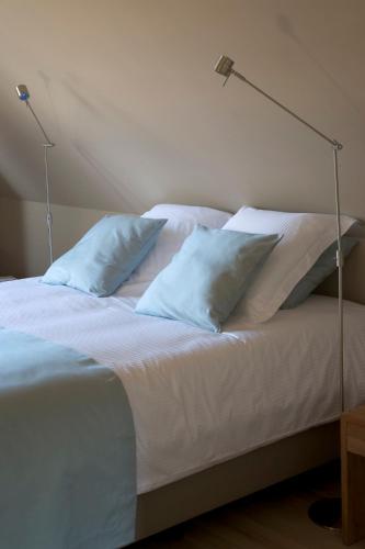 a white bed with two pillows and two lamps on it at Domus Portus in Dendermonde