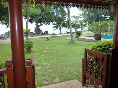 a porch with a view of a park with a dog at Baan Laem Noi Villa's in Mae Nam