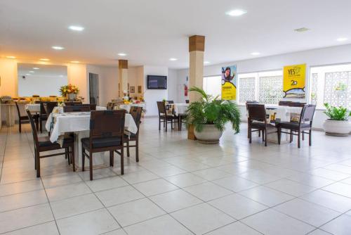 a dining room with tables and chairs in a restaurant at Costa do Rio Hotel in Petrolina