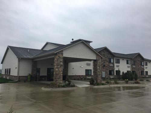 a large house with a garage in a parking lot at Cobblestone Inn & Suites - Monticello in Monticello