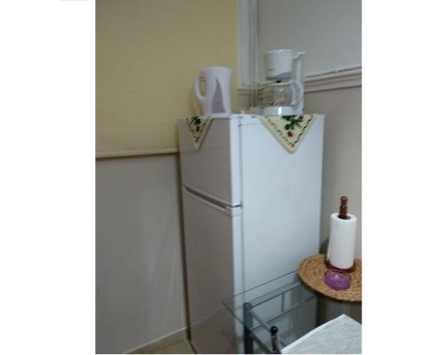 a white refrigerator in a corner of a room at The Sweetest Acropolis Flat in Athens