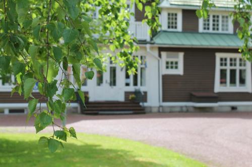 a white house with a green roof at Trunna Vandrarhem & Konferens in Orsa