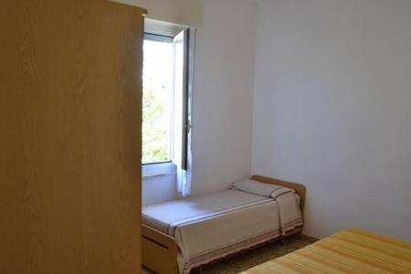 Habitación pequeña con cama y ventana en Appartamento a Cecina mare, en Marina di Cecina