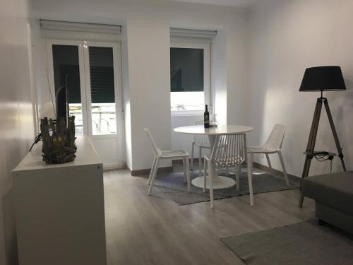 uma sala de estar branca com uma mesa e cadeiras em New Luxury Apartment - Lisbon Center em Lisboa