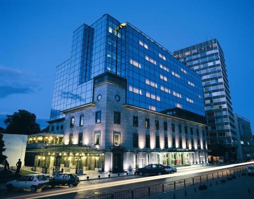 a large building with cars parked in front of it at Grand Hotel Sofia in Sofia