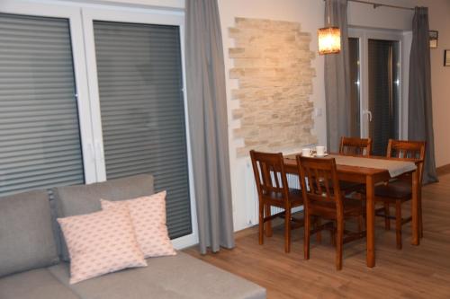 a dining room with a table and chairs and a couch at Apartament Pod Gondolą "9" in Świeradów-Zdrój