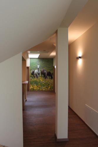 a hallway with a painting of horses in a field at Hotel Braun in Voitsberg