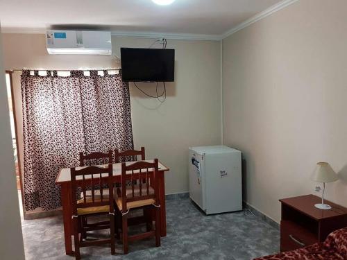 sala de estar con TV y nevera pequeña en Apart Hotel DEL LIBERTADOR en Salta