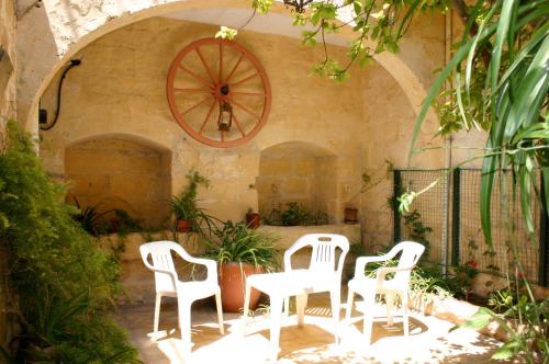 a group of white chairs sitting in a patio at Sylvia' s Millhouse in Kerċem
