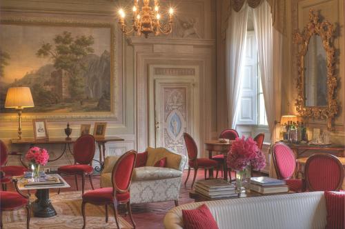 a living room with chairs and a couch and a chandelier at Palazzo Niccolini al Duomo Residenza D'Epoca in Florence