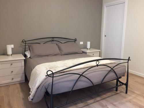 een slaapkamer met een bed met 2 nachtkastjes en 2 lampen bij B&B VESTA in Brescia