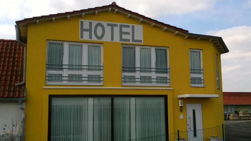 un edificio amarillo con un cartel de hotel en la casa mia, en Bad Langensalza