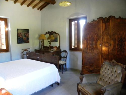 a bedroom with a bed and a chair and a dresser at Appartamenti Verde Collina Umbra in Bevagna