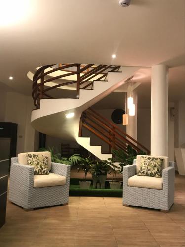 a lobby with two chairs and a staircase at Hotel La Isla in Puerto Ayora