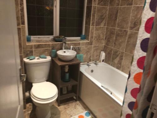 a bathroom with a toilet and a sink and a tub at Waltham Abbey Private Property in Waltham Abbey