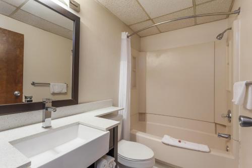 a bathroom with a sink and a toilet and a mirror at Days Inn & Suites by Wyndham Lancaster Amish Country in Lancaster