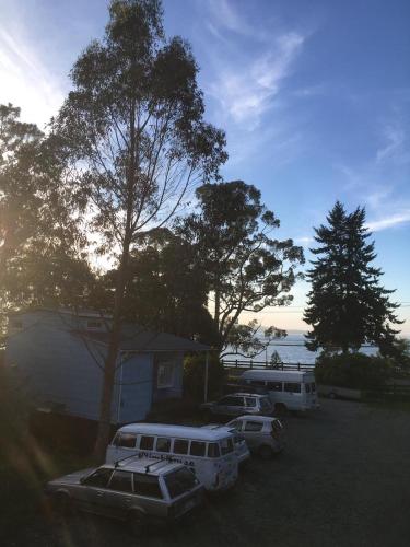 two buses parked in a parking lot next to a house at Hostal Climb House in Puerto Varas