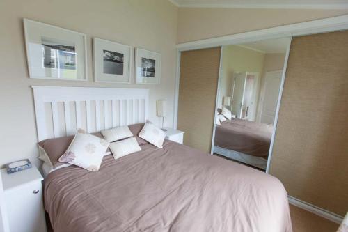 a bedroom with a large bed and a mirror at Cloughey holiday lodge in Kirkistown