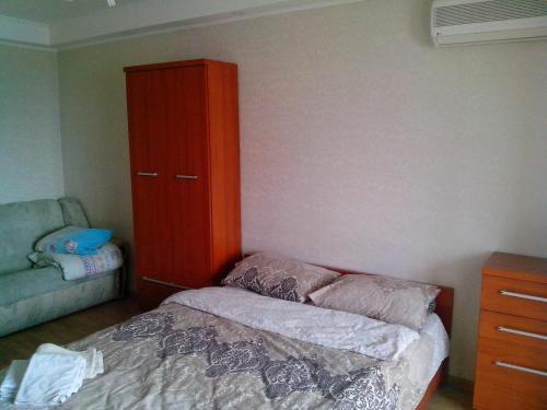 Homelike flat near the IEC on Levoberezhnaya في كييف: غرفة نوم مع سرير وخزانة حمراء