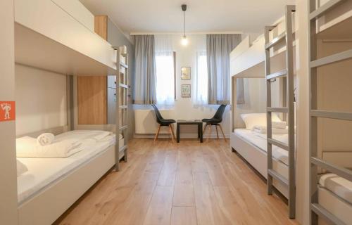 a room with two bunk beds and a table at Hostel Kucha in Sarajevo