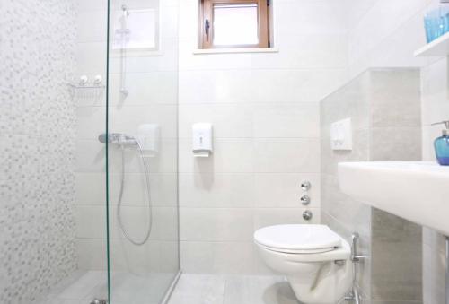uma casa de banho com um chuveiro, um WC e um lavatório. em Hostel Kucha em Saraievo