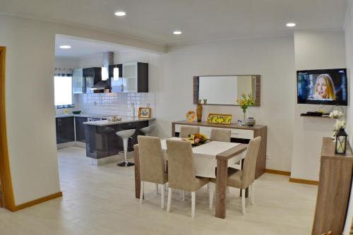a kitchen and dining room with a table and chairs at Casa da Água Quente 2 in Furnas