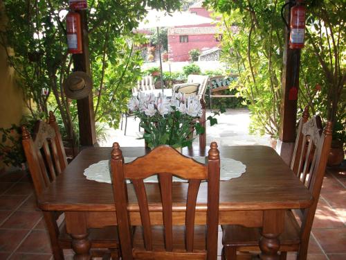 una mesa de madera con sillas y un jarrón de flores en Casa la Vistita, en Guía de Isora